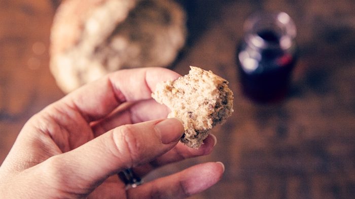 main tenant un morceau de pain pendant la Saint Cène