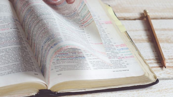 main feuilletant une bible pour l'annoter